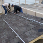 Solar students in St. Louis learn to install racking on a roof.