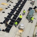 GRNE installers work on a large commercial rooftop project. 